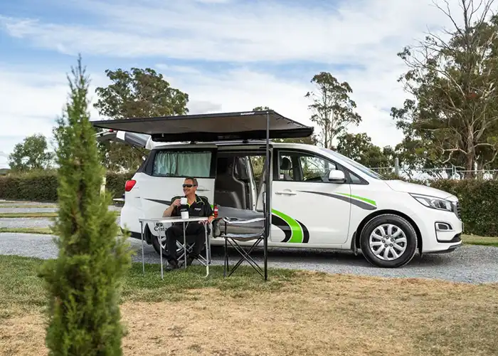 AR Camper Wagon with awning erected and a person enjoying the outdoors